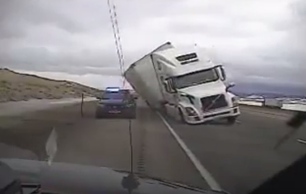 Video: Wind blows truck over onto police car, dashcam captures it