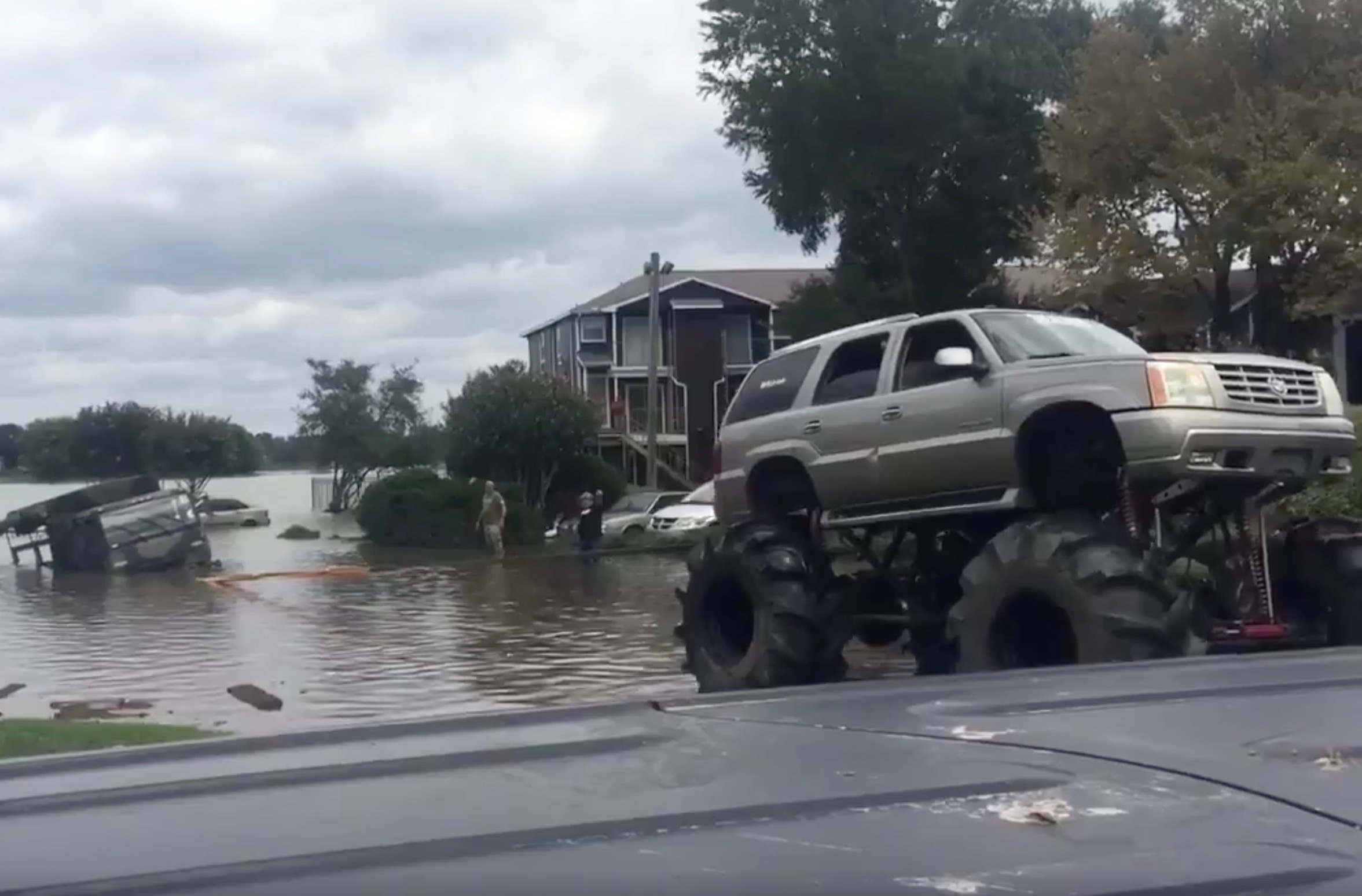 Monster trucks rescue stranded army truck in Houston floods (video)